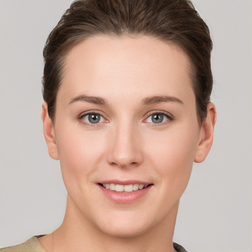 Joyful white young-adult female with short  brown hair and grey eyes