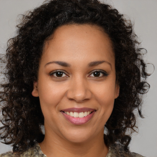 Joyful black young-adult female with medium  brown hair and brown eyes