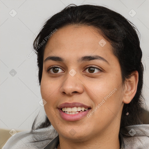 Joyful latino young-adult female with medium  brown hair and brown eyes