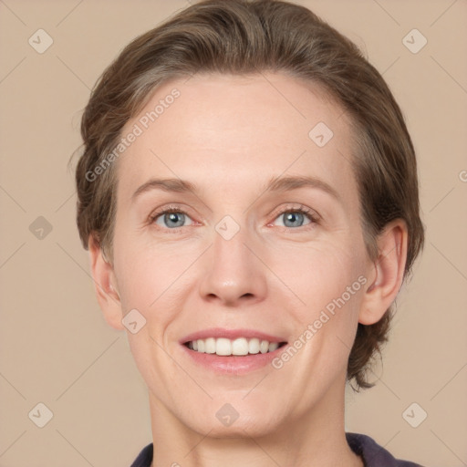 Joyful white adult female with medium  brown hair and grey eyes