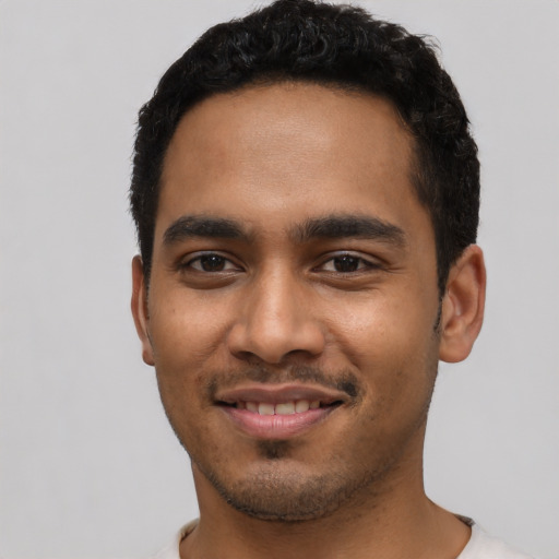 Joyful latino young-adult male with short  black hair and brown eyes