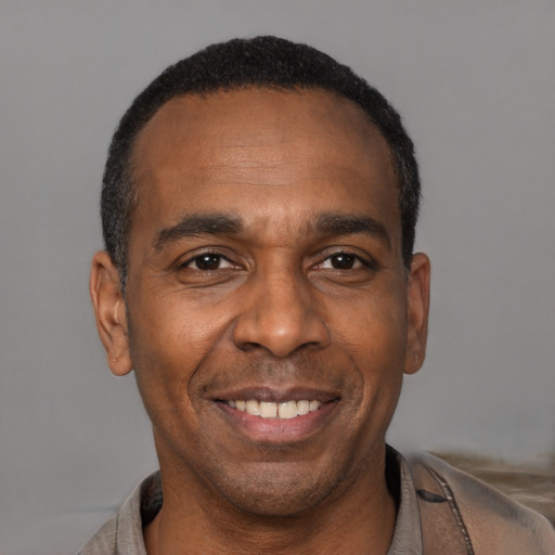 Joyful black adult male with short  black hair and brown eyes