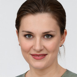 Joyful white young-adult female with medium  brown hair and grey eyes