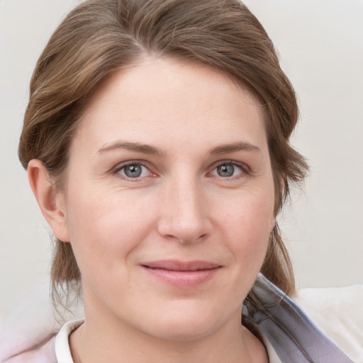 Joyful white young-adult female with medium  brown hair and grey eyes