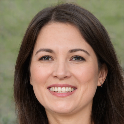 Joyful white adult female with long  brown hair and brown eyes