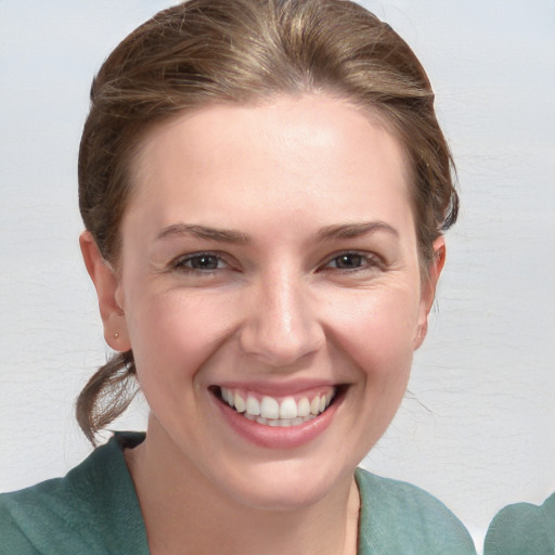 Joyful white young-adult female with medium  brown hair and grey eyes