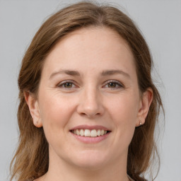 Joyful white young-adult female with medium  brown hair and grey eyes