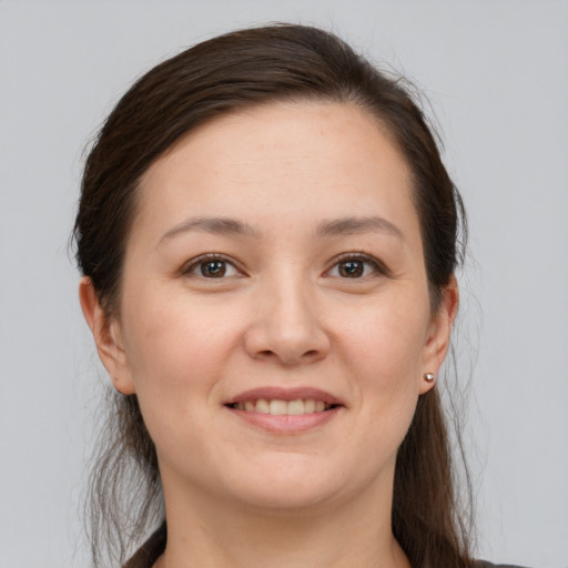 Joyful white young-adult female with long  brown hair and brown eyes