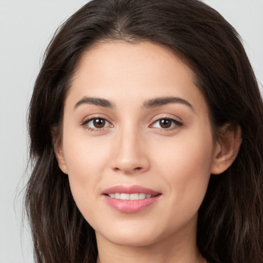 Joyful white young-adult female with long  brown hair and brown eyes