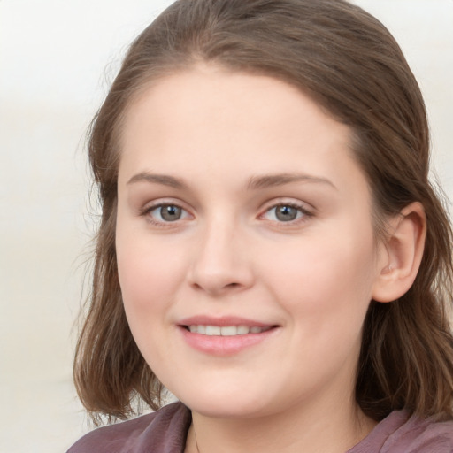 Joyful white young-adult female with long  brown hair and blue eyes