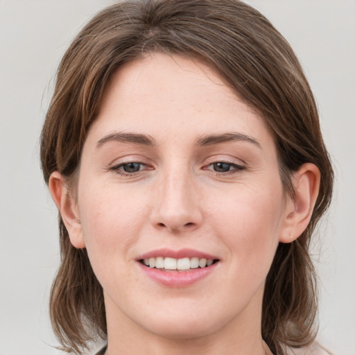 Joyful white young-adult female with medium  brown hair and blue eyes