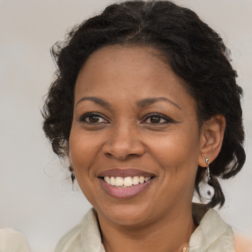 Joyful black adult female with medium  brown hair and brown eyes