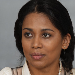 Joyful black young-adult female with medium  brown hair and brown eyes