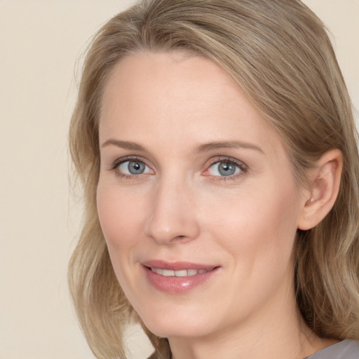 Joyful white young-adult female with medium  brown hair and blue eyes