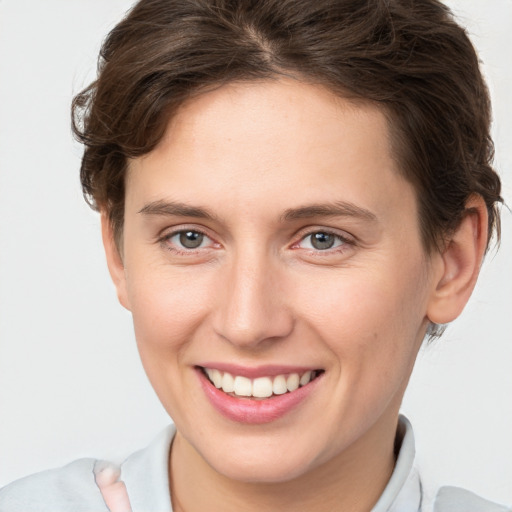 Joyful white young-adult female with short  brown hair and grey eyes