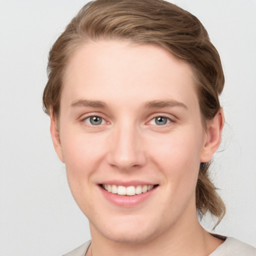 Joyful white young-adult female with short  brown hair and grey eyes