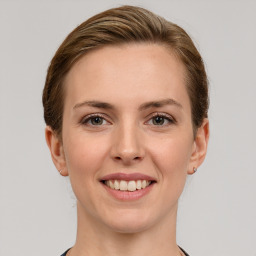 Joyful white young-adult female with medium  brown hair and grey eyes