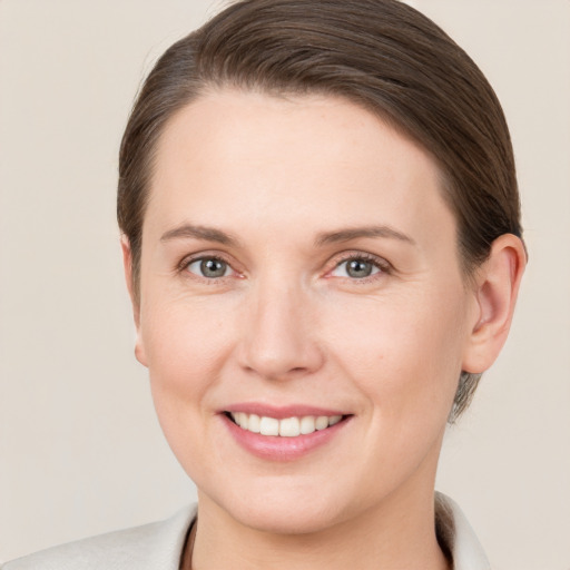 Joyful white young-adult female with short  brown hair and grey eyes