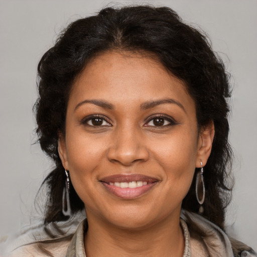 Joyful black adult female with medium  brown hair and brown eyes