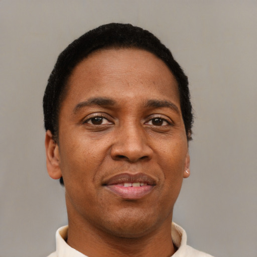 Joyful black young-adult male with short  brown hair and brown eyes