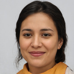 Joyful latino young-adult female with medium  brown hair and brown eyes