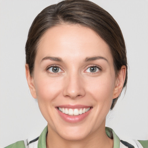 Joyful white young-adult female with medium  brown hair and green eyes