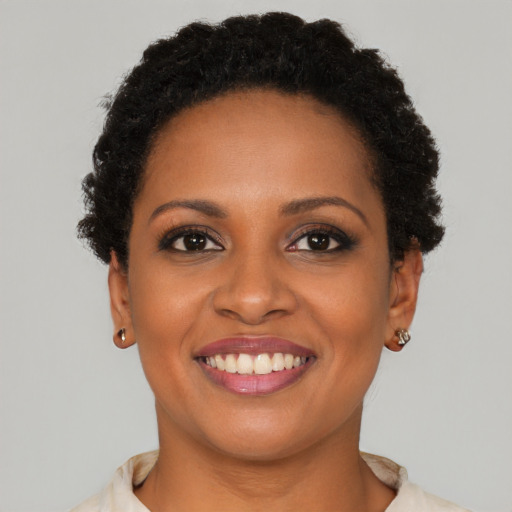 Joyful black young-adult female with short  brown hair and brown eyes