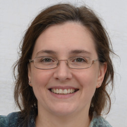 Joyful white adult female with medium  brown hair and blue eyes