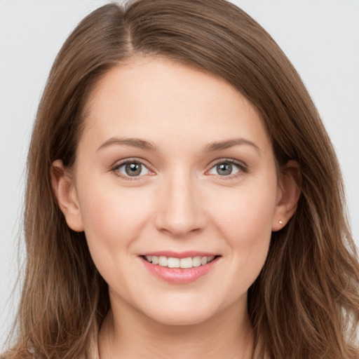 Joyful white young-adult female with long  brown hair and grey eyes