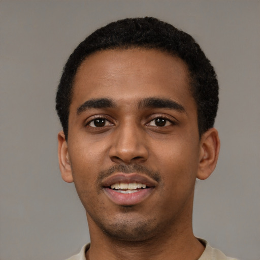 Joyful black young-adult male with short  black hair and brown eyes