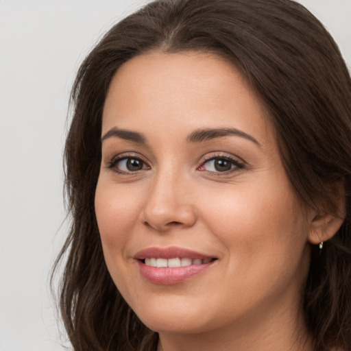 Joyful white young-adult female with long  brown hair and brown eyes