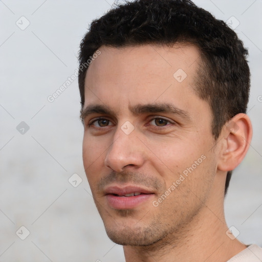 Joyful white young-adult male with short  black hair and brown eyes