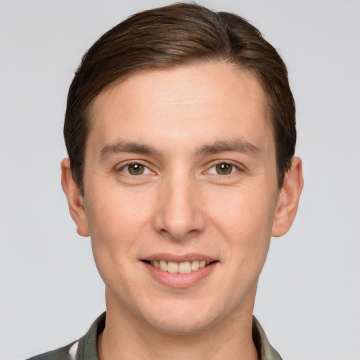 Joyful white young-adult male with short  brown hair and grey eyes