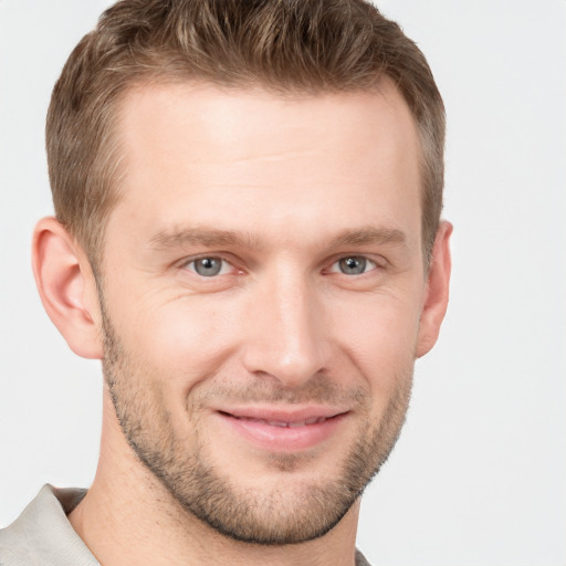 Joyful white young-adult male with short  brown hair and grey eyes