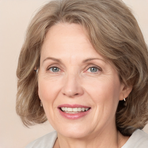 Joyful white adult female with medium  brown hair and grey eyes