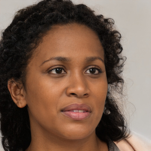 Joyful black young-adult female with long  brown hair and brown eyes