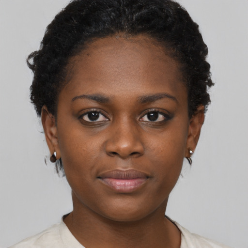 Joyful black young-adult female with short  brown hair and brown eyes