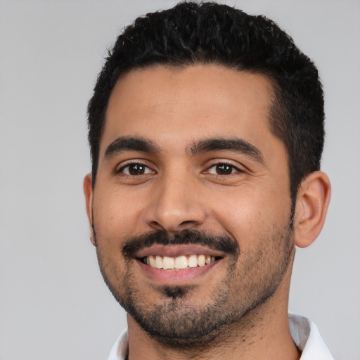 Joyful latino young-adult male with short  black hair and brown eyes