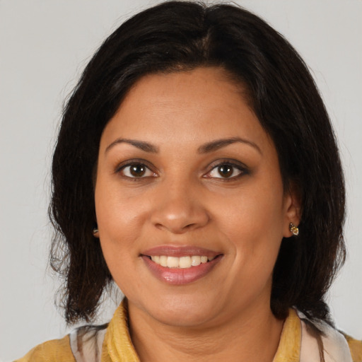 Joyful black young-adult female with medium  brown hair and brown eyes