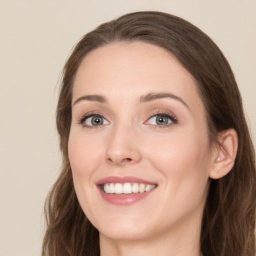 Joyful white young-adult female with long  brown hair and blue eyes