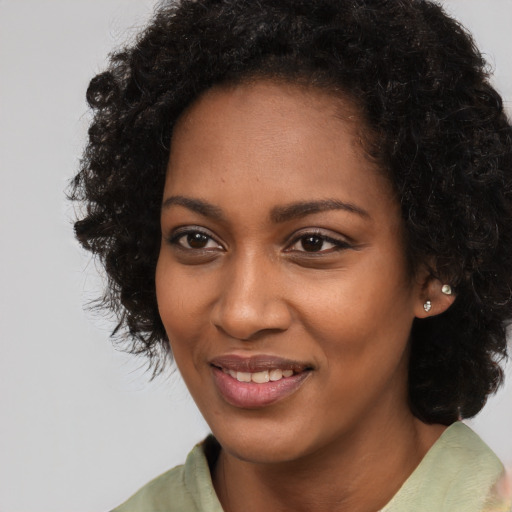 Joyful black young-adult female with long  black hair and brown eyes