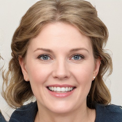 Joyful white young-adult female with medium  brown hair and blue eyes