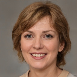 Joyful white young-adult female with medium  brown hair and grey eyes