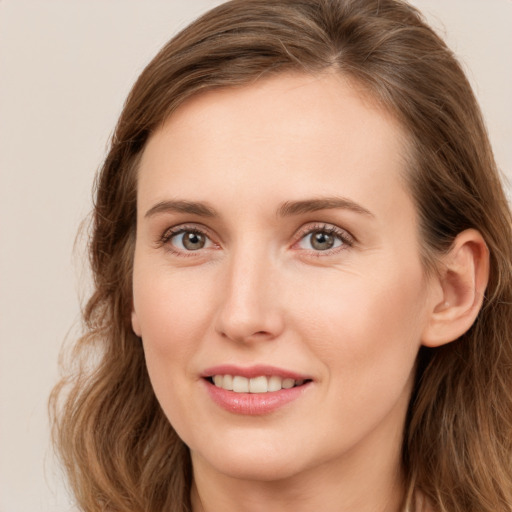 Joyful white young-adult female with long  brown hair and blue eyes