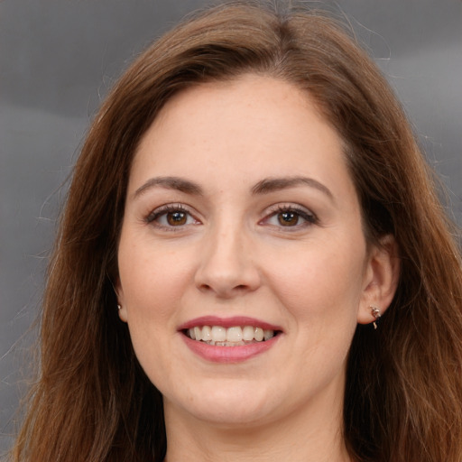 Joyful white adult female with long  brown hair and brown eyes