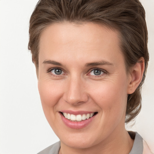 Joyful white young-adult female with medium  brown hair and grey eyes