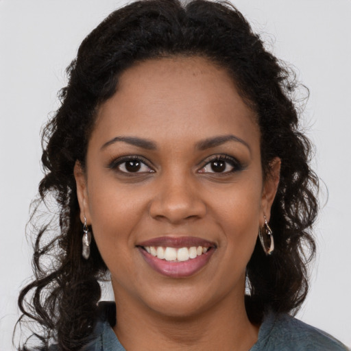 Joyful black young-adult female with long  brown hair and brown eyes