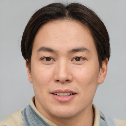 Joyful asian young-adult male with short  brown hair and brown eyes