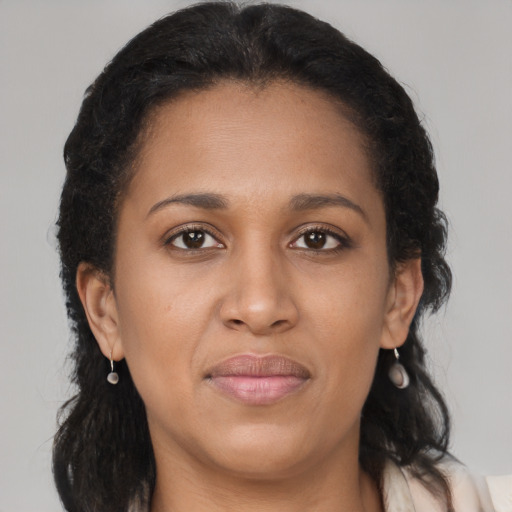 Joyful black young-adult female with long  brown hair and brown eyes