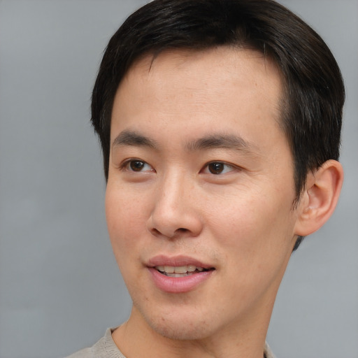 Joyful asian young-adult male with short  brown hair and brown eyes